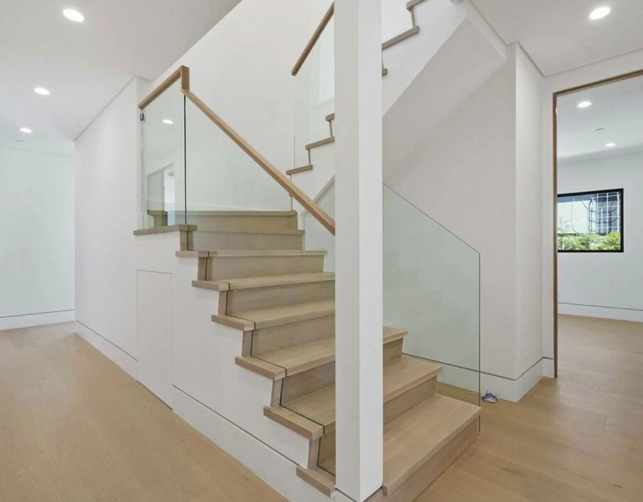 Modern staircase remodeling project by WW Builders in Los Altos, California with glass railing design